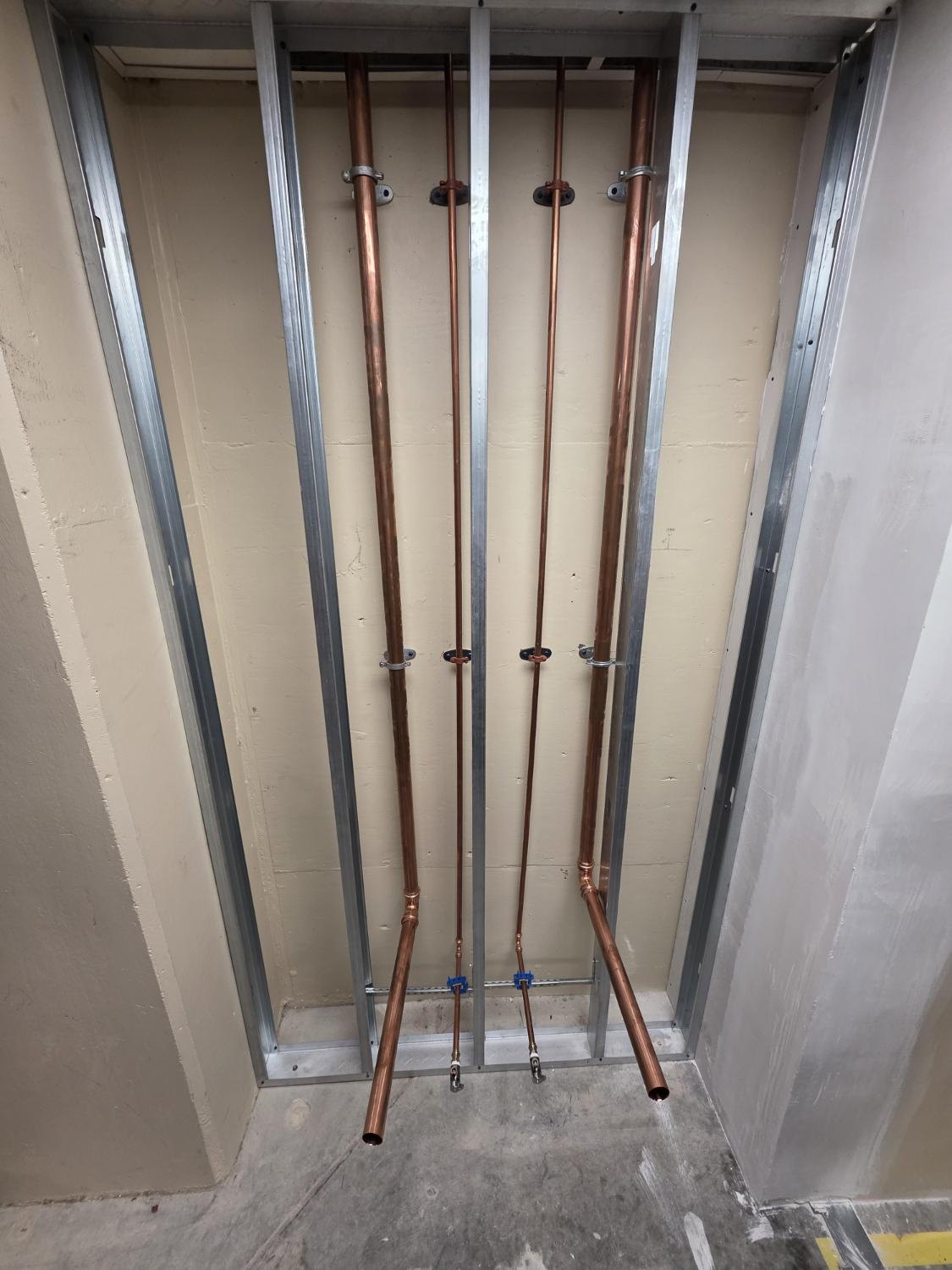 Copper supply lines roughed in on a metal stud wall